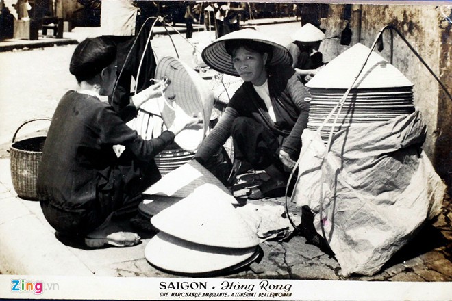 Một gánh hàng rong bán nón lá trên đường phố Sài Gòn. Nón lá  là nón đội đặc trưng của người Việt, được làm từ lá cọ lợp trên nên khung tre nhỏ hình chóp nhọn dưới có quai đeo, nón rộng vành nên che kín mặt và rất mát.